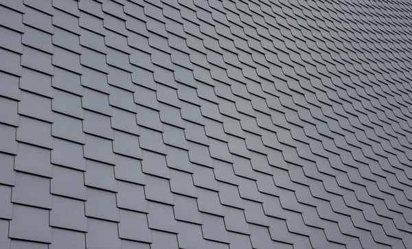 Extérieur, vue en contre-plongée d'une toiture pyramidale en ardoises avec charpente apparente et girouette décorative au sommet